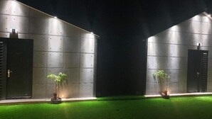 A modern building with two large doors, each with a small potted plant in front. - BlackJazz Inn (Puli)