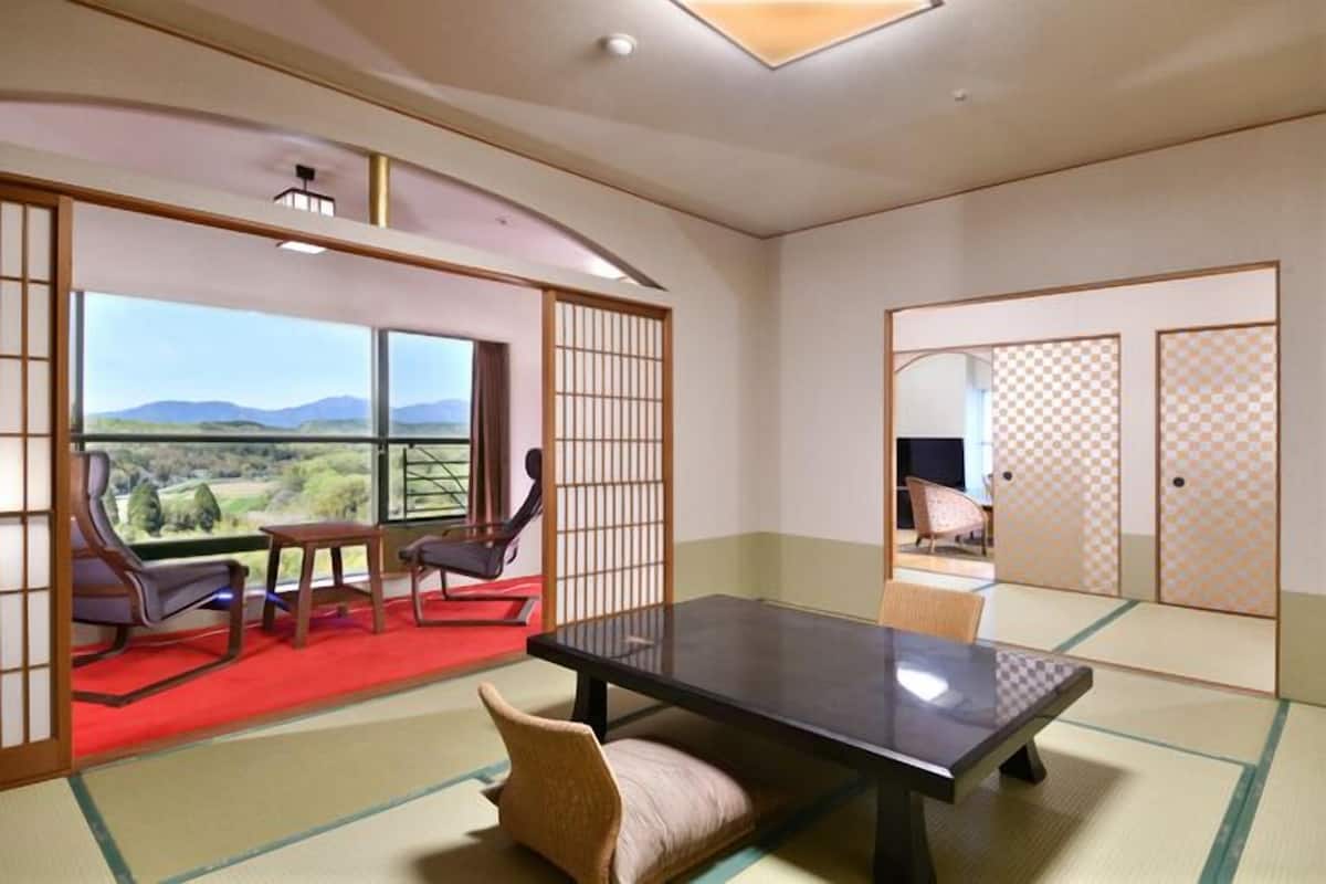 A traditional Japanese room with tatami flooring, a low table, and sliding doors.