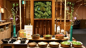 A buffet setup with various food items and decorative plants. - Yunogo Onsen HOTEL YUNOMORI (Mimasaka)