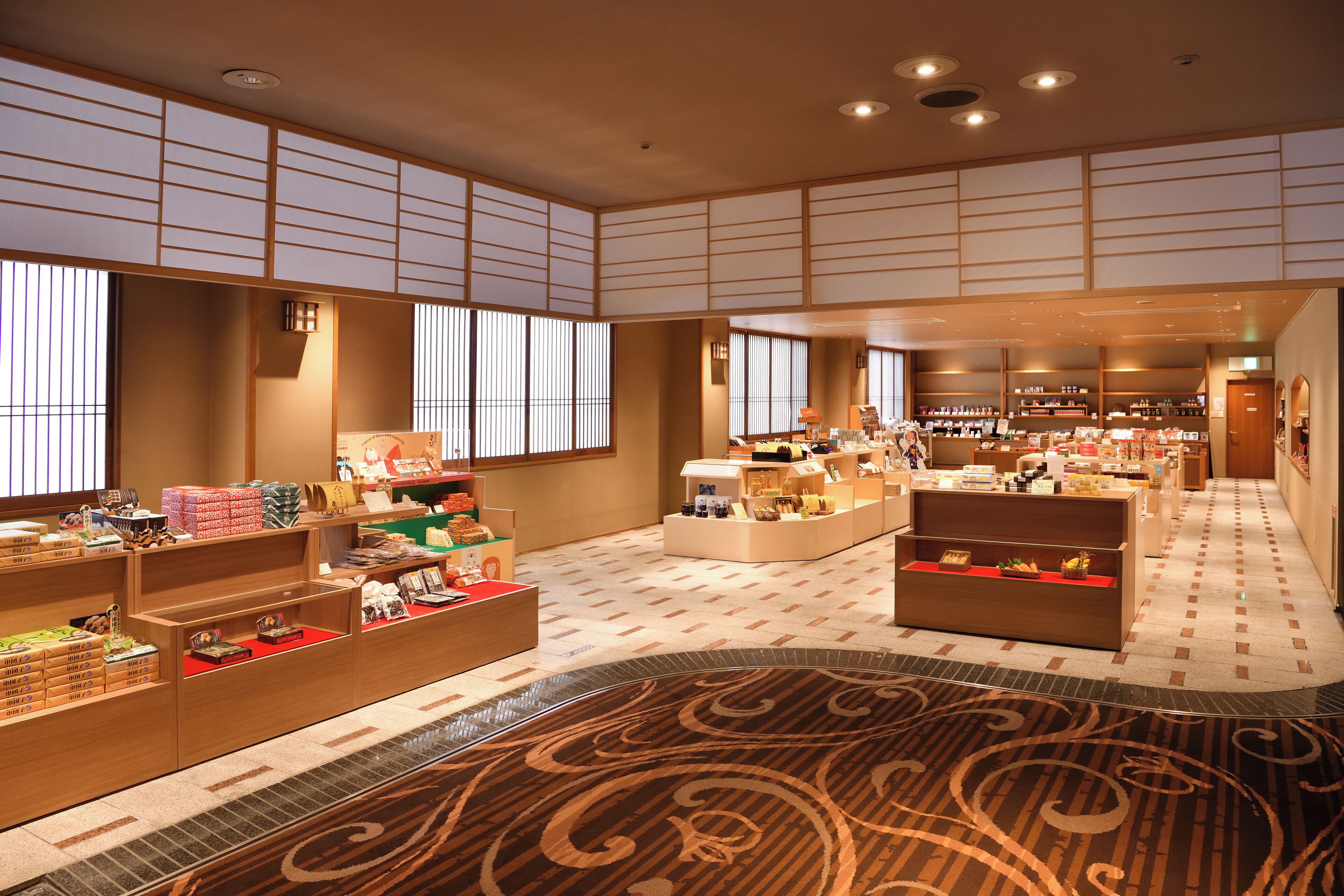 Un hall d’entrée spacieux, décoré dans le style traditionnel japonais, avec notamment des tatamis et des paravents shoji, ainsi qu’une variété de présentoirs de produits à la vente.