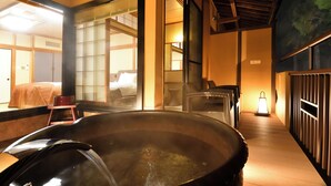 A traditional Japanese room with tatami flooring, a large hot spring bath, and sliding doors. - Yunogo Onsen HOTEL YUNOMORI (Mimasaka)