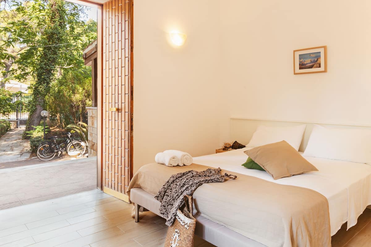 Un dormitorio con cama, ventana y puerta.