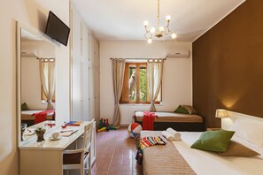 Une chambre à coucher comprenant un lit, un bureau, une chaise, une télévision, une fenêtre et un lustre.