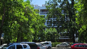 A parking lot with several cars, trees, and a building with 'ELSE' on the facade. - Semiramis Hotel (Saturn)