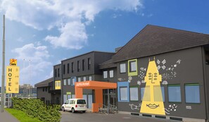 A modern hotel with a Jufa logo, a parking area, and a van parked in front. - JUFA Hotel Graz Süd - Self Check-in (Graz)