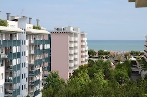 Un quartier résidentiel situé sur la côte, avec des immeubles à plusieurs étages, des balcons et une vue sur la mer.