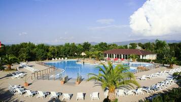 Una piscina al aire libre de temporada, sombrillas