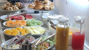 A buffet with various food items, including fruits, pastries, and beverages. - Arch Rome Suites (Rome)