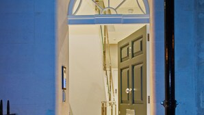An arched entrance to a building with a door and a handrail. - Bath Circle (Bath)