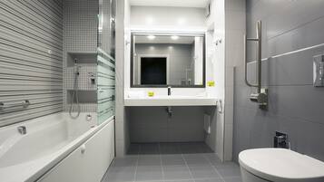 A modern bathroom with a bathtub, a sink, and a toilet.