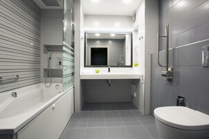 A modern bathroom with a bathtub, a sink, and a toilet.