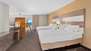 A hotel room with two beds, a desk, and a view of the ocean. - Americana Motor Inn (Ocean City)