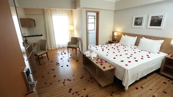 Una habitación de hotel con cama, escritorio, silla, espejo y puerta.