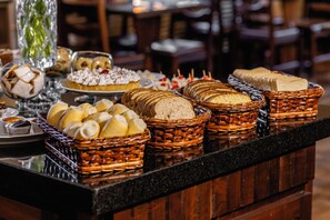 A buffet with various breads, pastries, and desserts. - Hotel Petrópolis (Nova Petropolis)