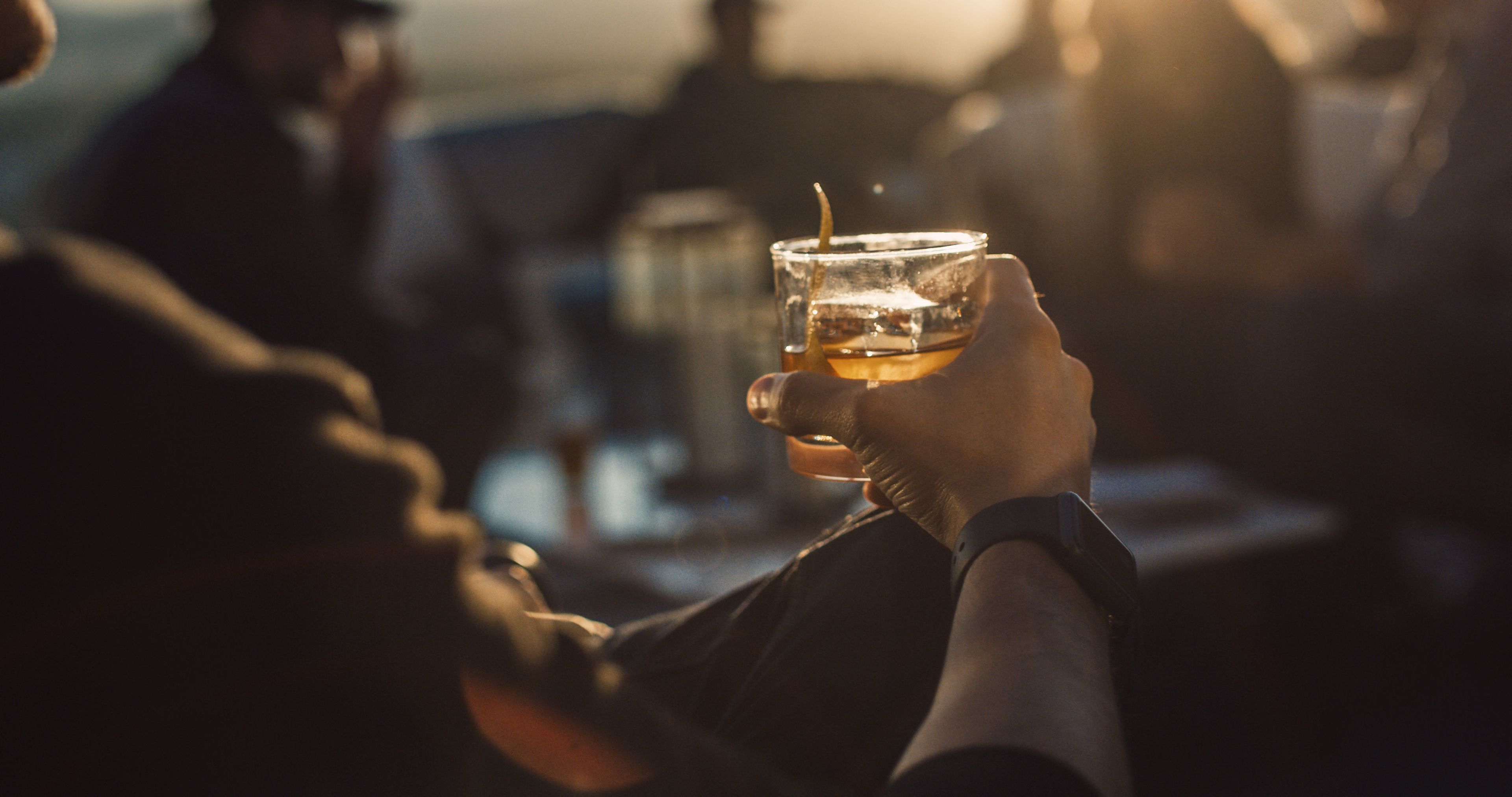 Una persona sosteniendo un vaso de whisky.