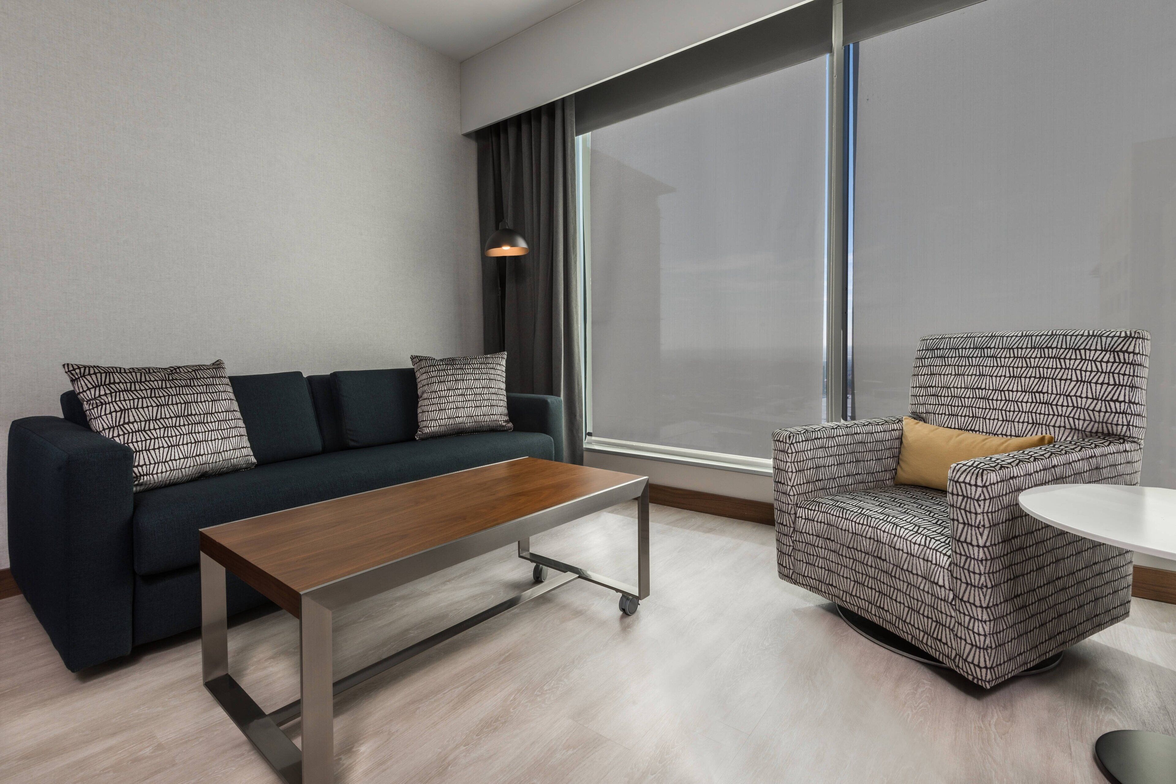 Een moderne woonkamer met een bank, fauteuil en salontafel.