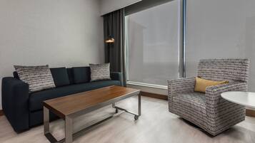 A modern living room with a sofa, armchair, and coffee table.