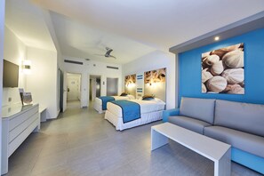 A modern hotel room with two beds, a sofa, a desk, and a large wall art piece.