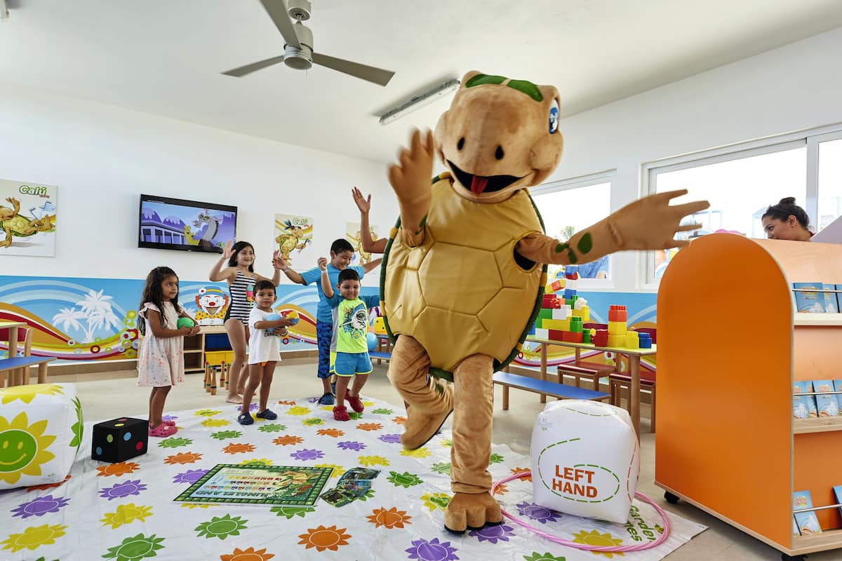 A child-friendly room with a mascot, colorful play area, and educational materials.