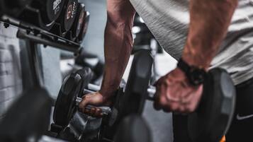A close-up of a person using a dumbbell on a bench.
