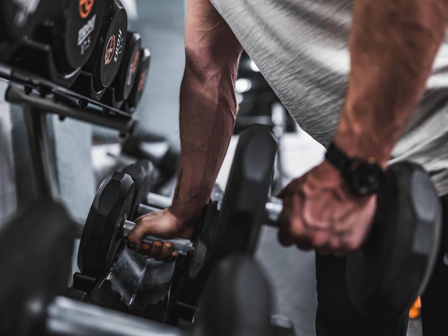 A close-up of a person using a dumbbell on a bench.
