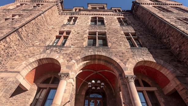 A historic building with a symmetrical facade, large arched windows, and a prominent central entrance.