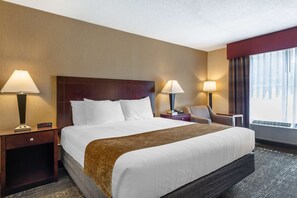 A hotel room with a large bed, two bedside tables with lamps, a chair, and a window with curtains. - Best Western Braintree Inn (Braintree)