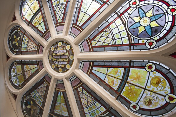 A stained glass ceiling with geometric patterns and floral designs.