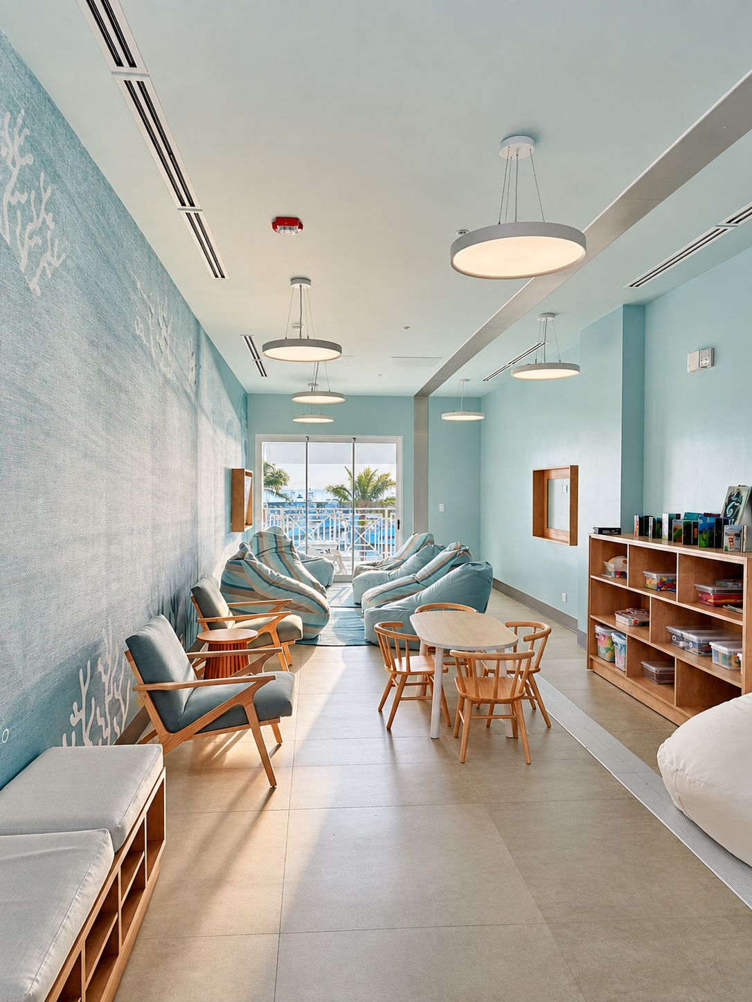 A modern lounge area with seating, a pool view, and a bookshelf.
