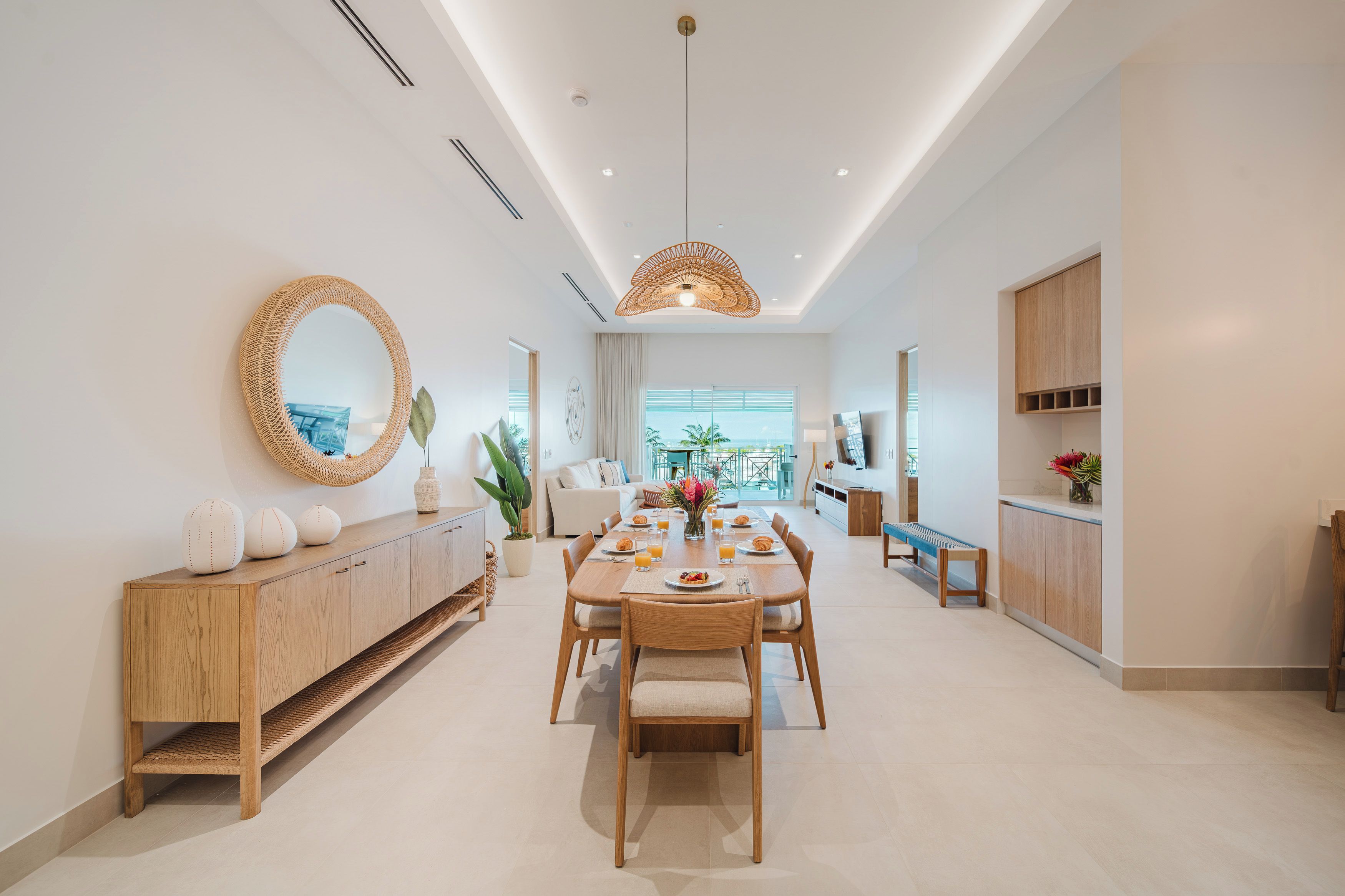 A modern dining area with a wooden table, chairs, and a buffet cabinet.