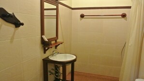 A small bathroom with a sink, mirror, and towel rack. - Villa Champa (Luang Prabang)