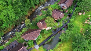 Un petit village avec des maisons traditionnelles, une rivière et un pont.