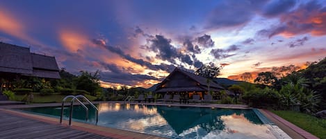 Una piscina al aire libre, sombrillas, tumbonas