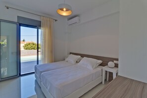 Un dormitorio moderno con una cama grande, una mesita de noche y una lámpara de techo.