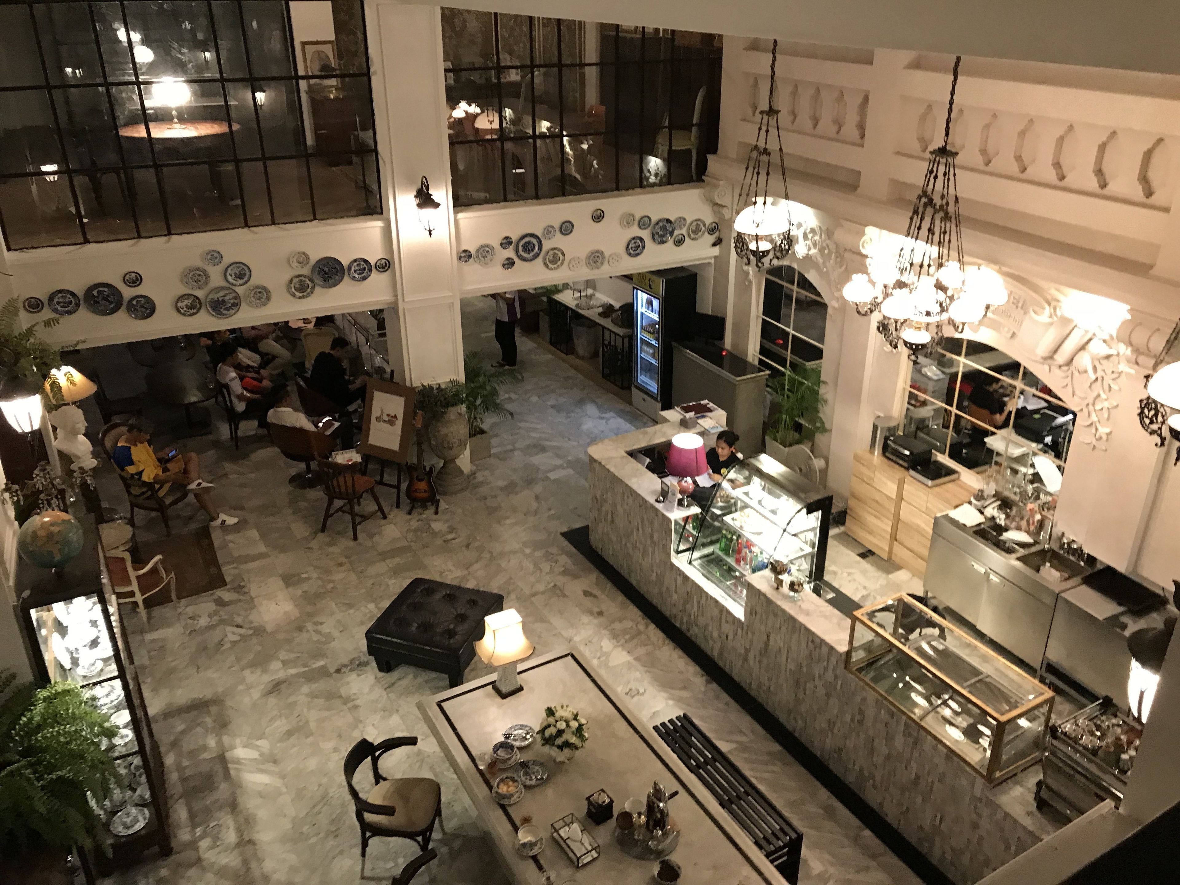 A spacious lobby with a central seating area, a bar, and a dining area.