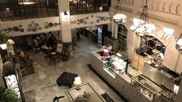 A spacious lobby with a central seating area, a bar, and a dining area.
