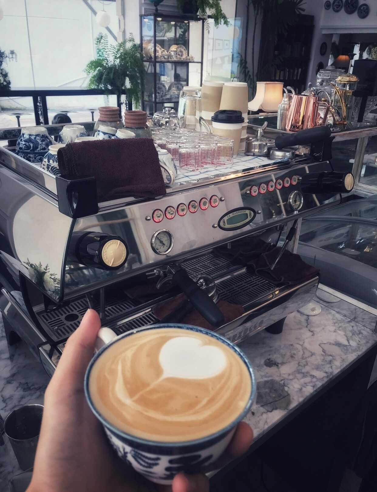 Eine Kaffeemaschine mit einer Tasse Kaffee im Vordergrund.