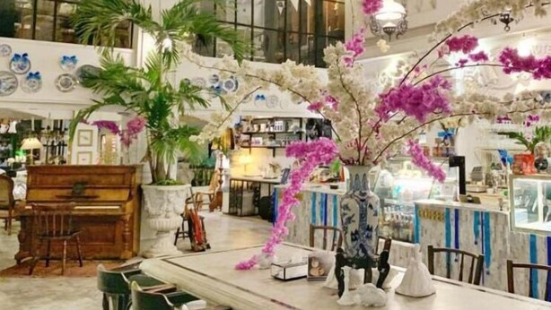 A spacious room with a large dining table, chairs, and a piano. There are potted plants and a vase with flowers. - Yuu Hotel Ubon Ratchathani (Ubon Ratchathani)