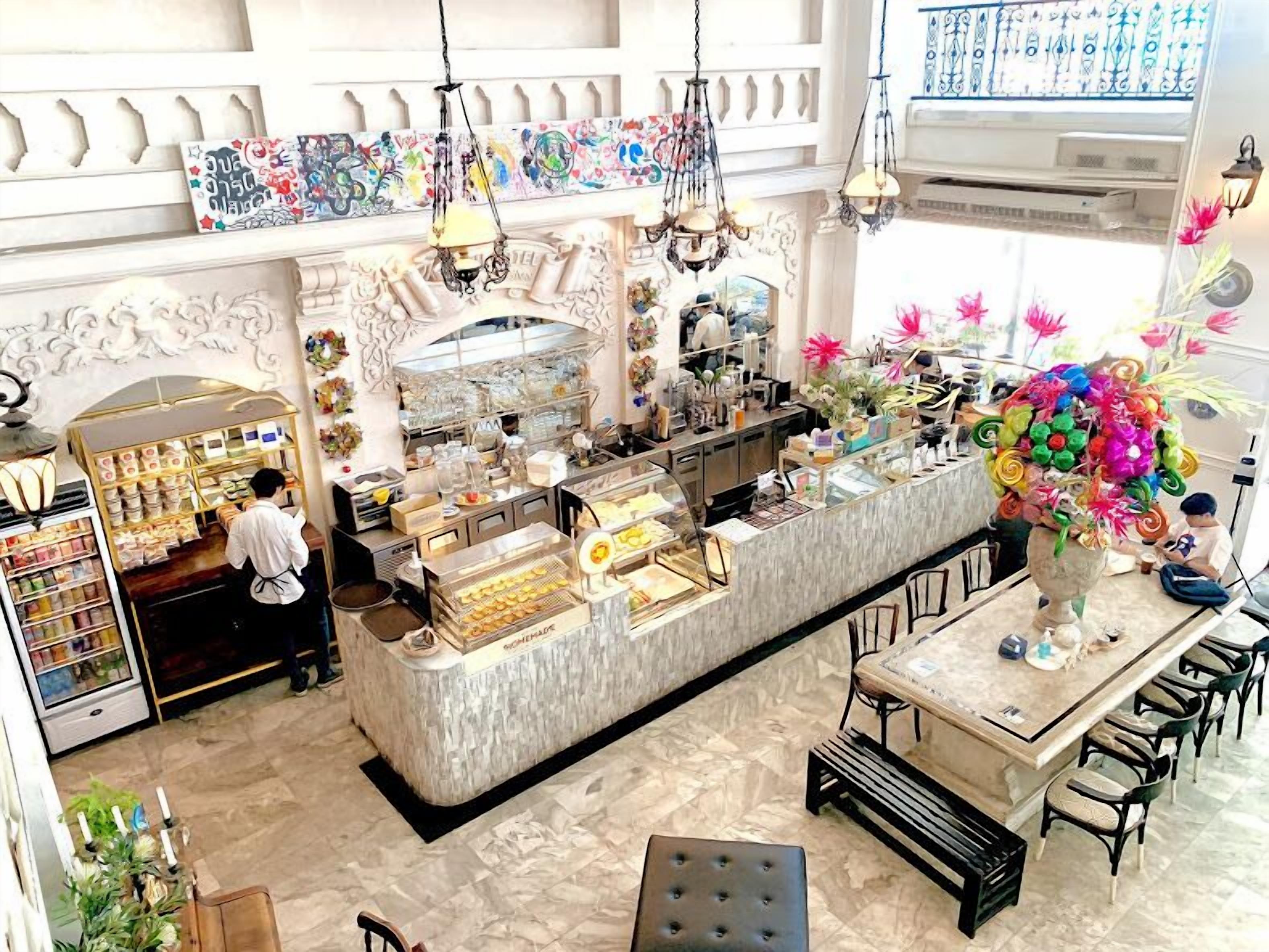 A restaurant with a marble counter, hanging lights, and a decorative wall.