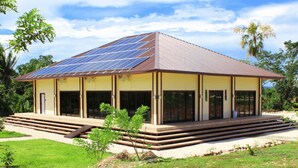 Un edificio con techo solar, ventanas amplias y porche cubierto.