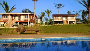 Un complejo turístico con piscina, edificios de dos pisos y palmeras.