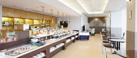 A buffet setup with various food items and a seating area with tables and chairs.