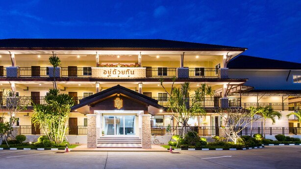 Un hotel de varios pisos con una entrada destacada, balcones e iluminación exterior.