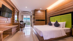 Una habitación de hotel moderna con una cama grande, televisión, escritorio y vistas al exterior.