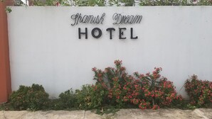 Pared blanca con el texto "Shamish Dream Hotel" en letras negras.