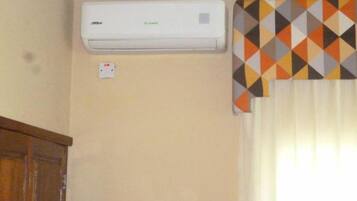 Un aire acondicionado instalado en la pared, con un enchufe debajo.
