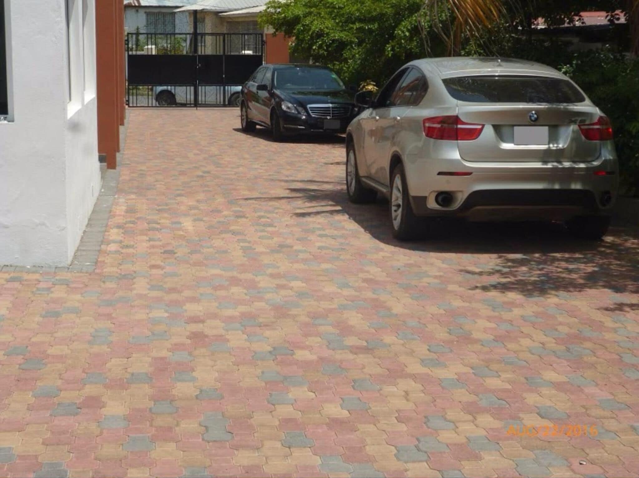 A paved driveway leading to a parked car.