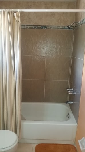 A bathroom with a bathtub, a shower, and a toilet.