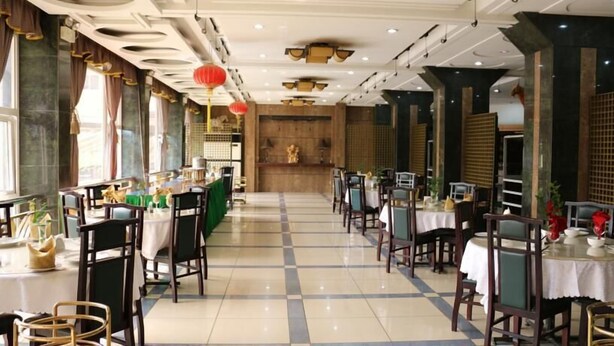 A restaurant with a checkered floor, wooden chairs, and tables set with white tablecloths. - Golden Gate Hotel Abuja (Abuja)