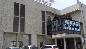 A building with a sign reading "Parkview Hotels." It features a textured facade, multiple windows, and a balcony area. - Parkview Hotel Abuja (Abuja)